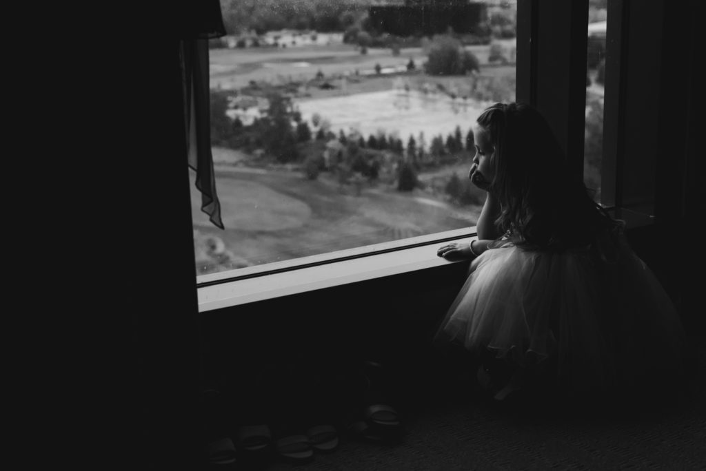 flower girl looking out the hotel window