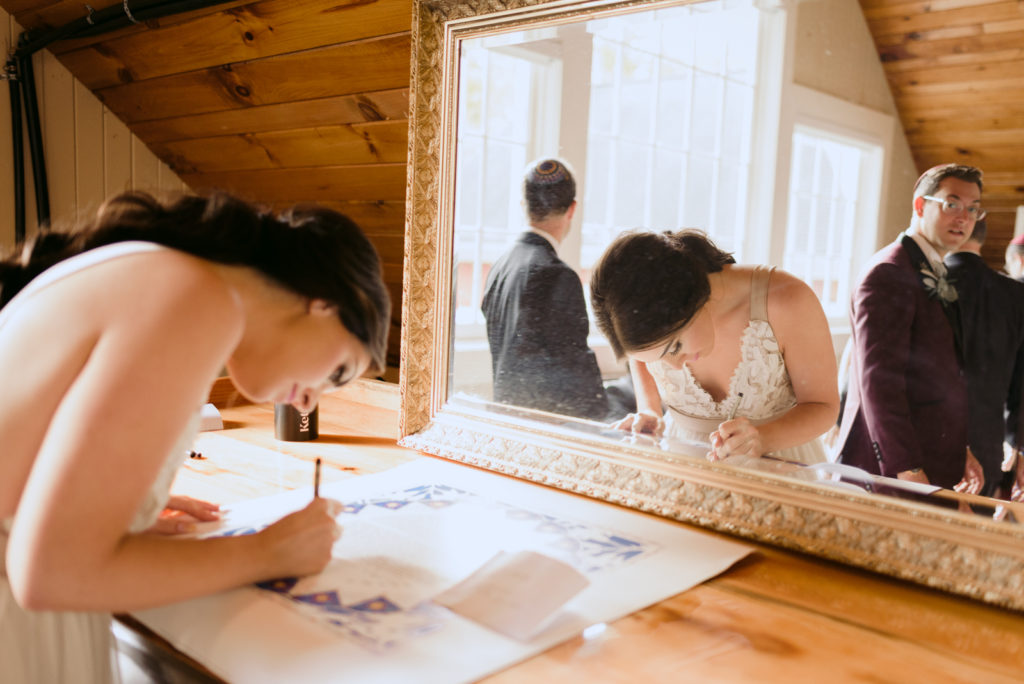 bride signing the ketubah