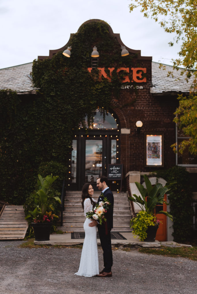 bride and groom in front of orange art gallery