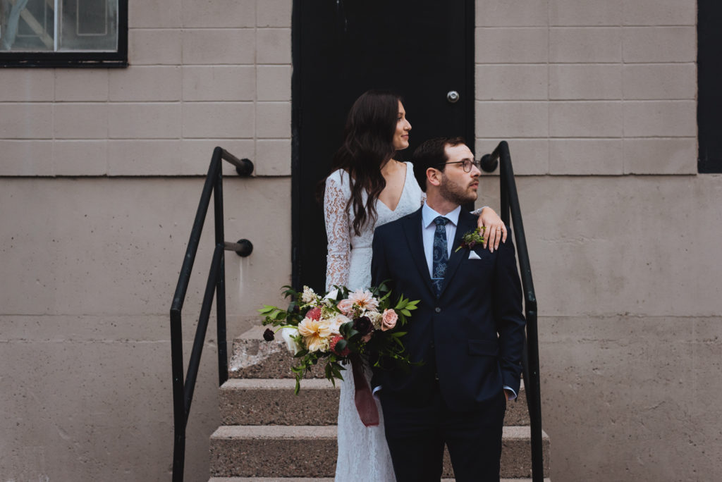 bride and groom standing on a staircase in a parking lot