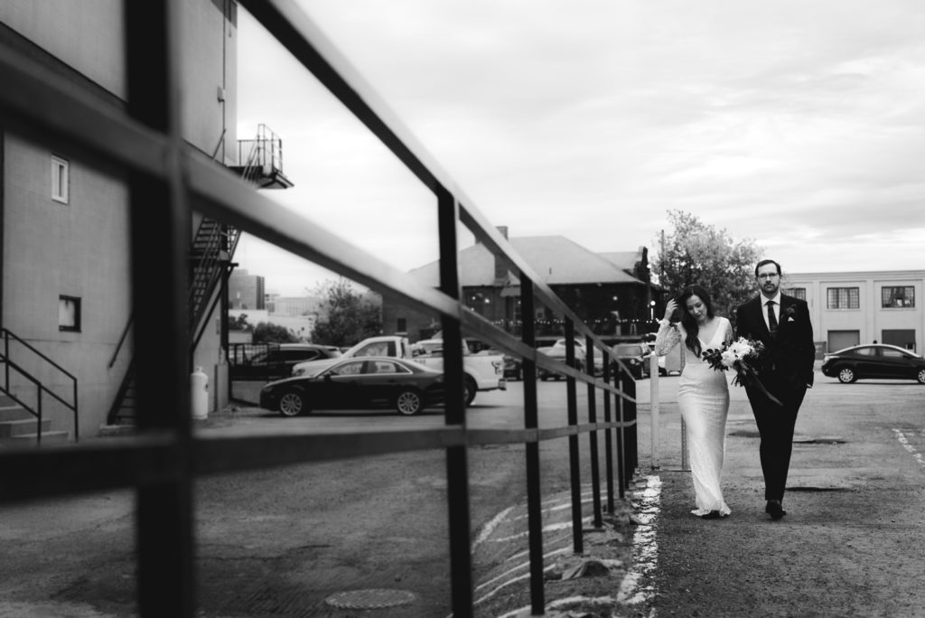 bride and groom walking in a parking lot