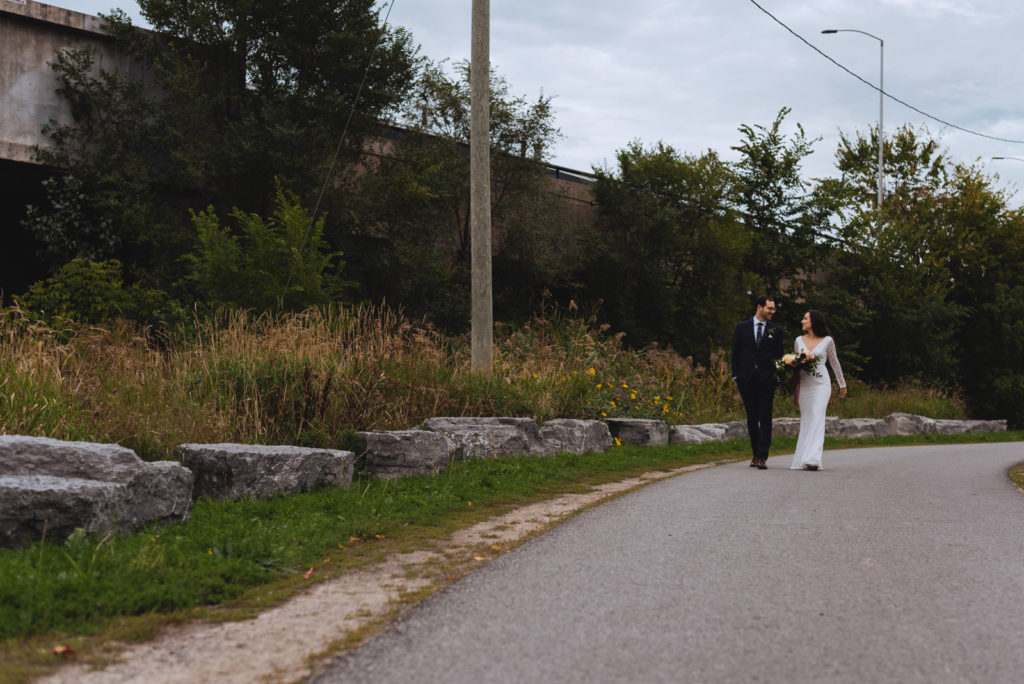bride and groom walking down a bike path