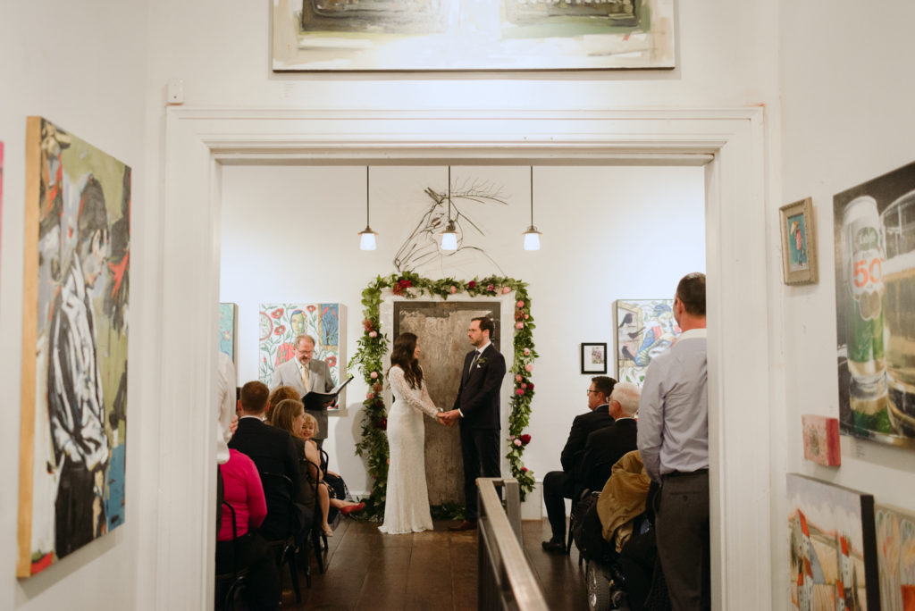 bride and groom in front of metal door at the orange art gallery wedding