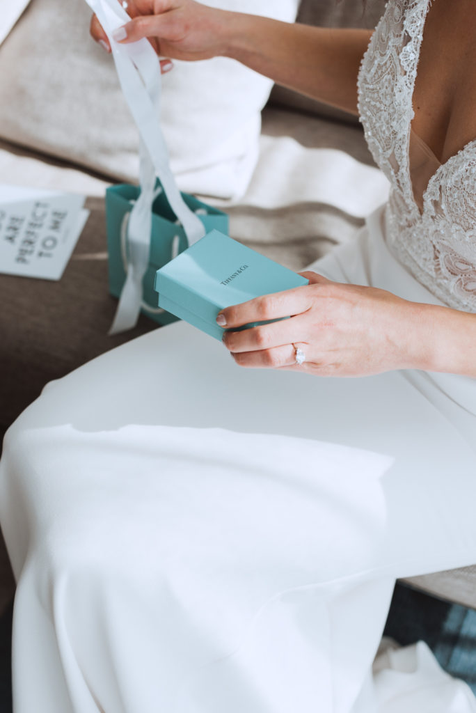 bride opening a gift from her groom at the andaz hotel
