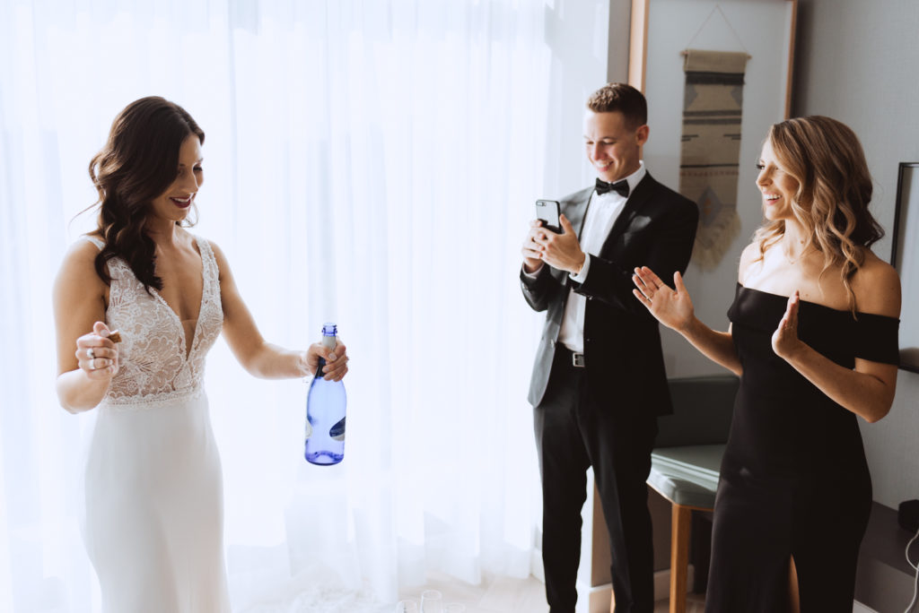 bride opening bottle of champagne at the andaz hotel