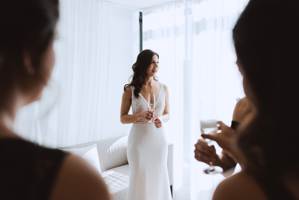bride holding champagne with her wedding party at the andaz hotel