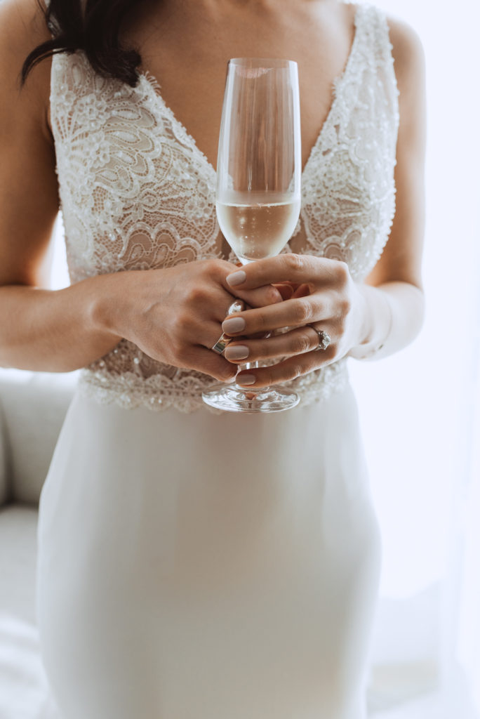 bride holding champagne flute in the sunlight