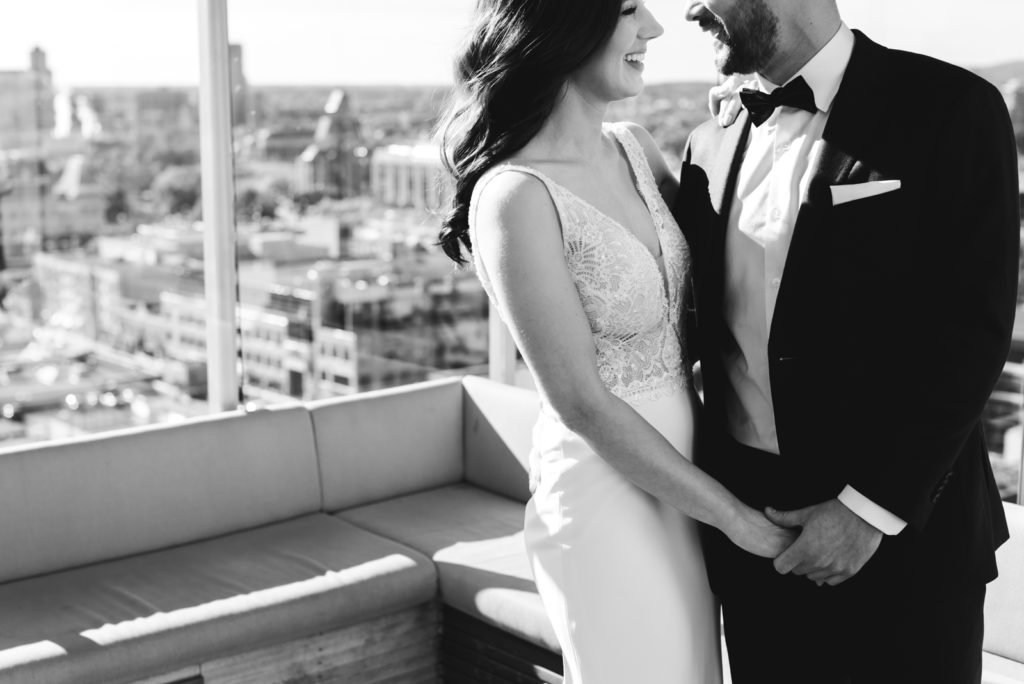 bride and groom holdings hands getting close on the andaz hotel rooftop