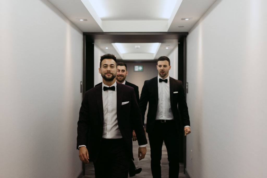 groom and groomsmen walking down the hall at the andaz hotel