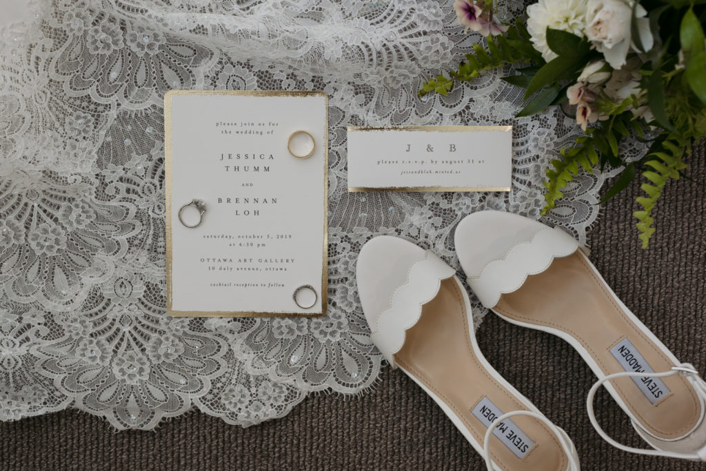 flat lay of wedding dress and wedding invitations and rings at the andaz hotel