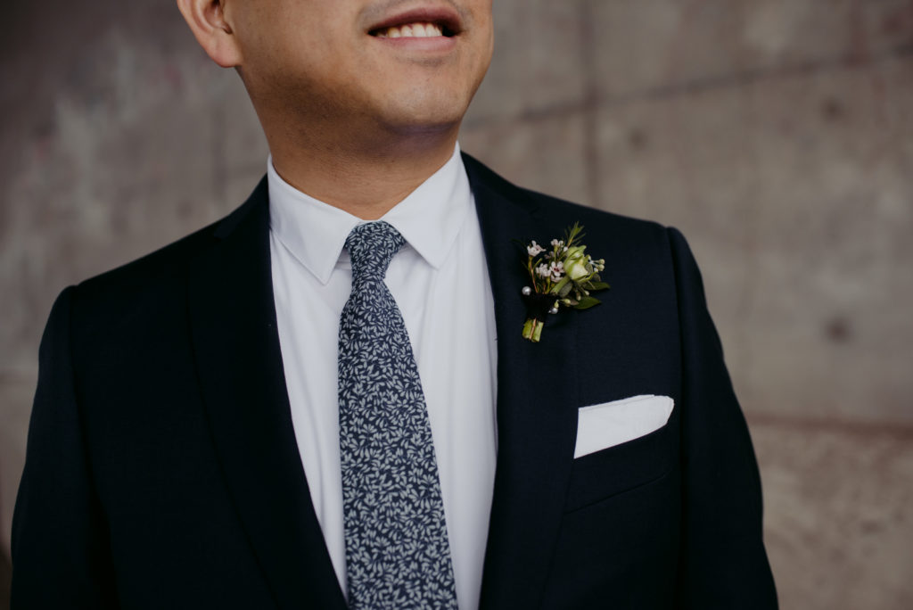 boutonniere pinned on groom's suit