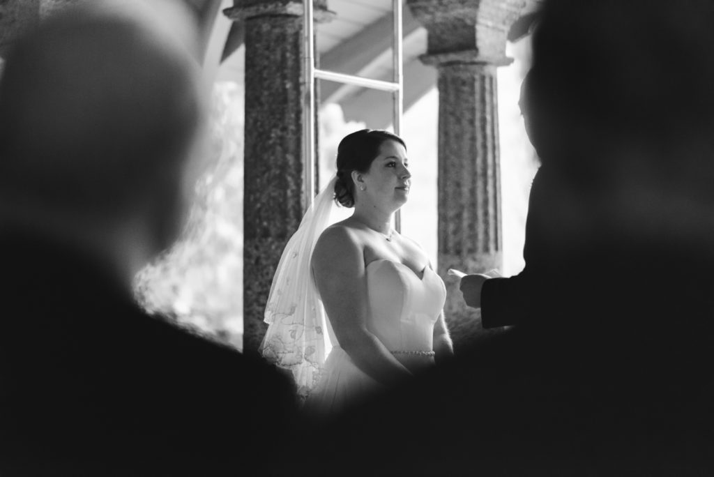 bride listening to groom read his vows during wedding ceremony