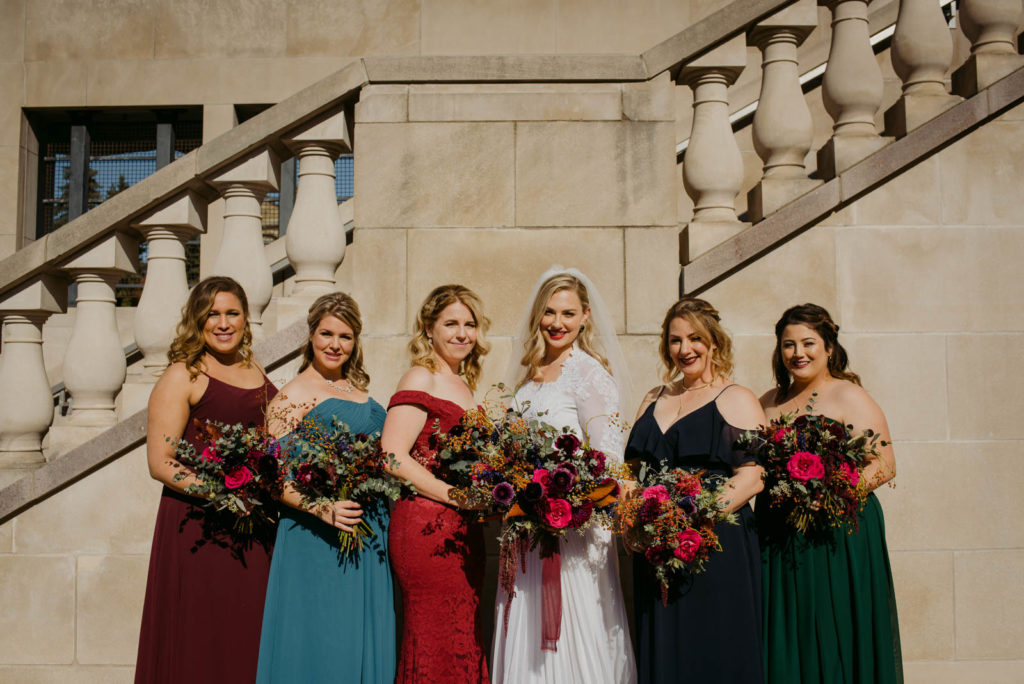 bridal party wearing bright colourful dresses outside the chateau laurier