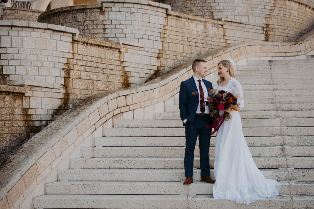 bride and groom on concrete staircase at the Museum of History