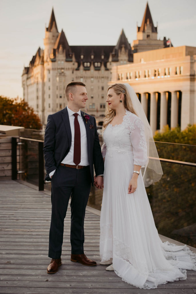 bride and groom cuddling at sunset at the NAC in Ottawa with Chateau Laurier in the background