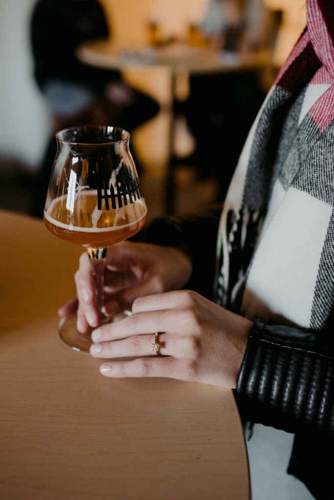 engaged woman holding Beyond the Pale beer glass with engagement ring