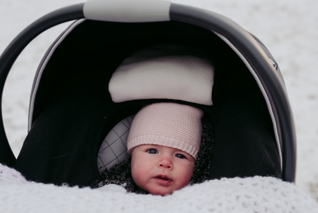 baby girl in car seat outdoors during winter