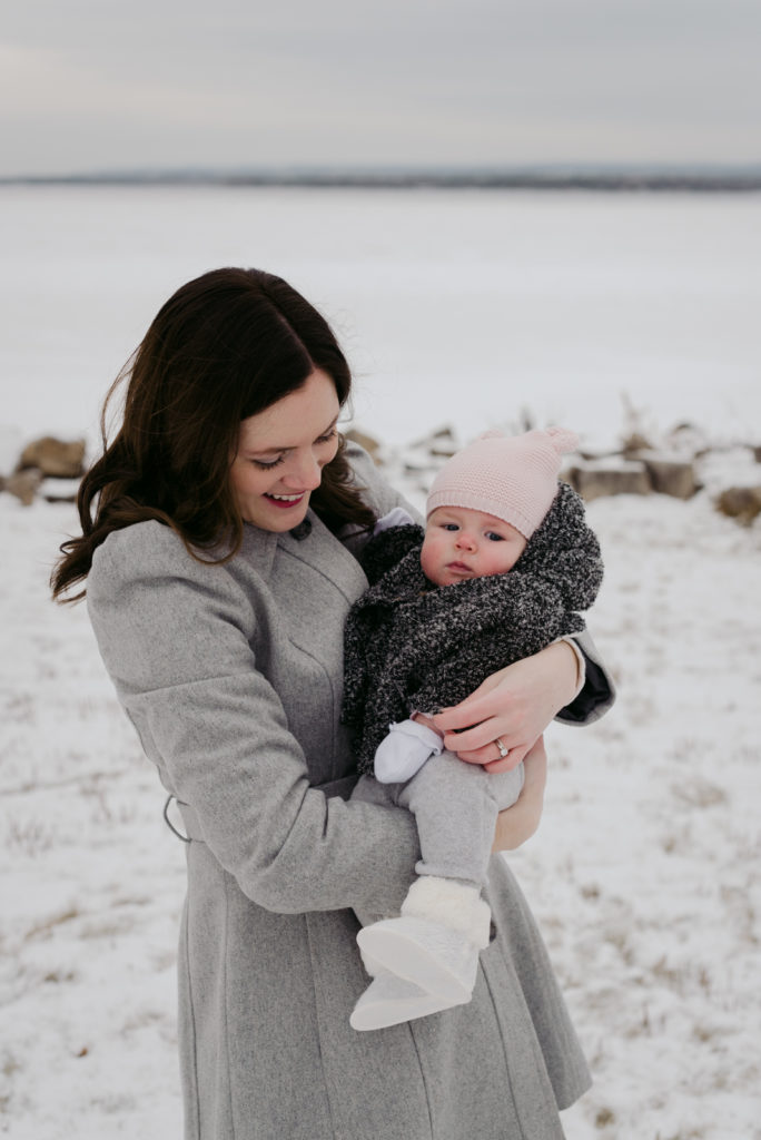 mom holding baby girl outside in winter
