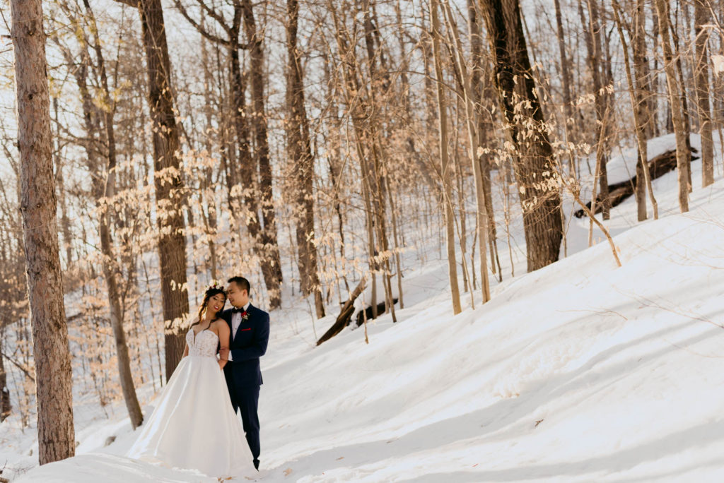 bride and groom in the woods at sunset in the winter