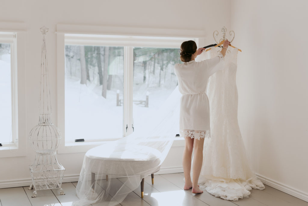 bride taking her dress of a hanger