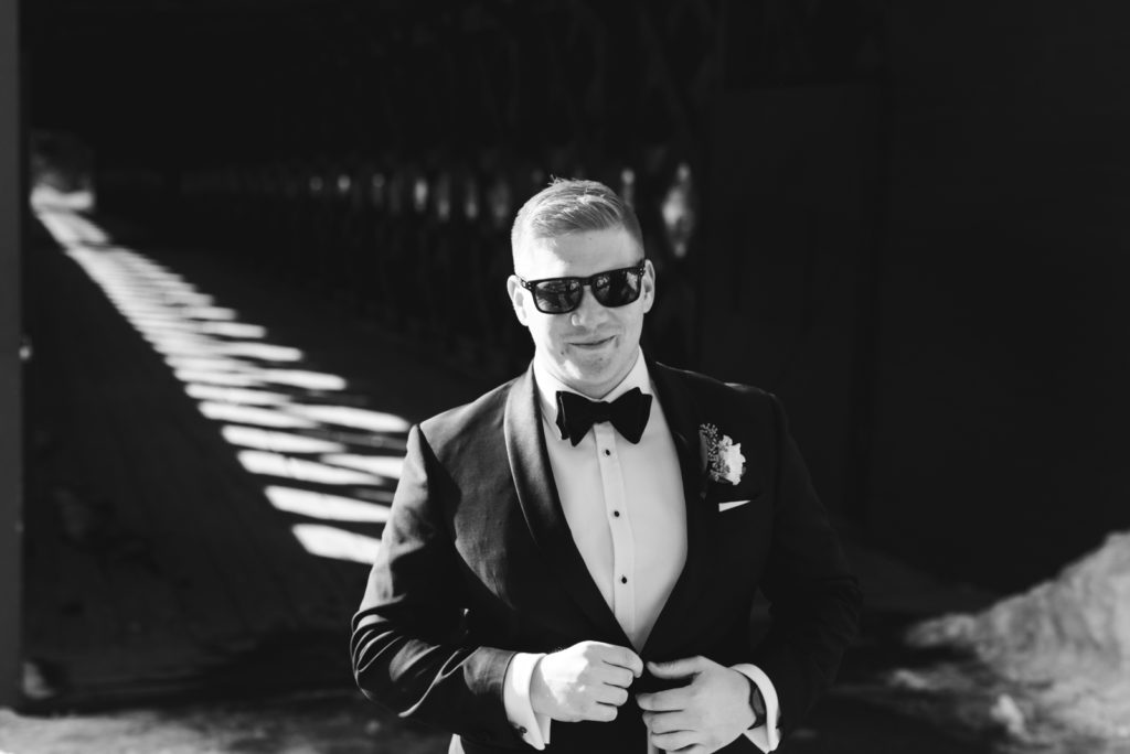 groom wearing sunglasses in a tux on the wakefield bridge in gatineau