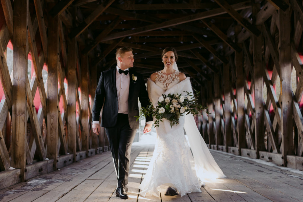bride and groom walking on the wakefield covered bridge
