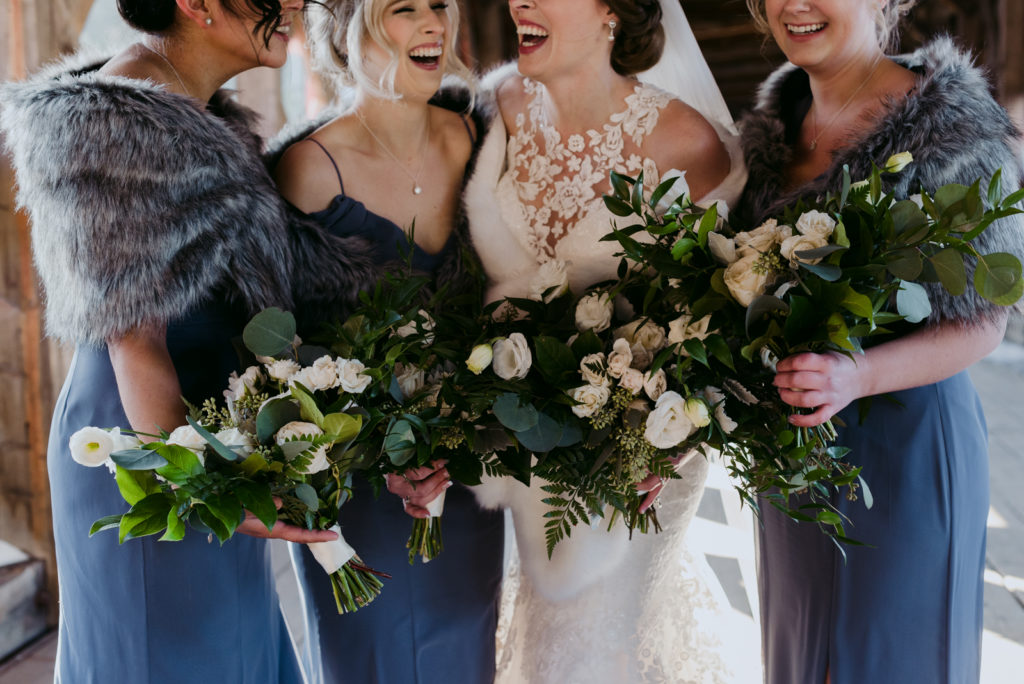 bridesmaids in blue laughing with bride on the wakefield covered bridge