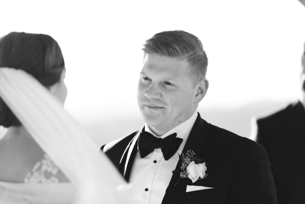 groom smiling at the bride during ceremony