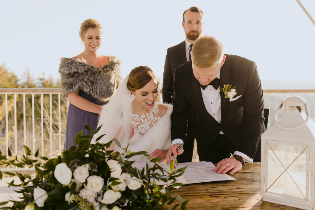 bride and groom signing the marriage license during winter wedding at le belvedere in wakefield