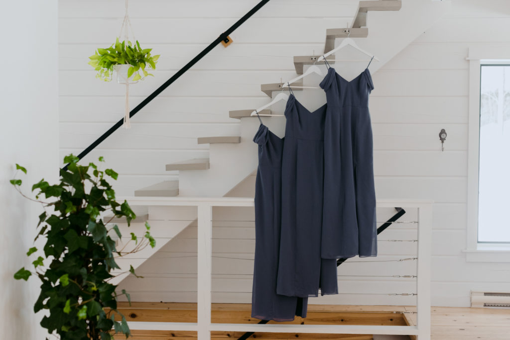 blue bridesmaids dresses hanging on staircase