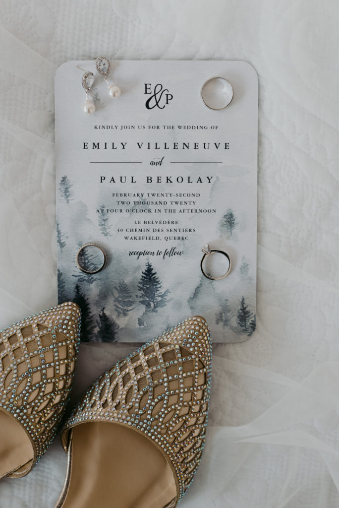 wedding invitation and sparkly wedding shoes and rings flat lay