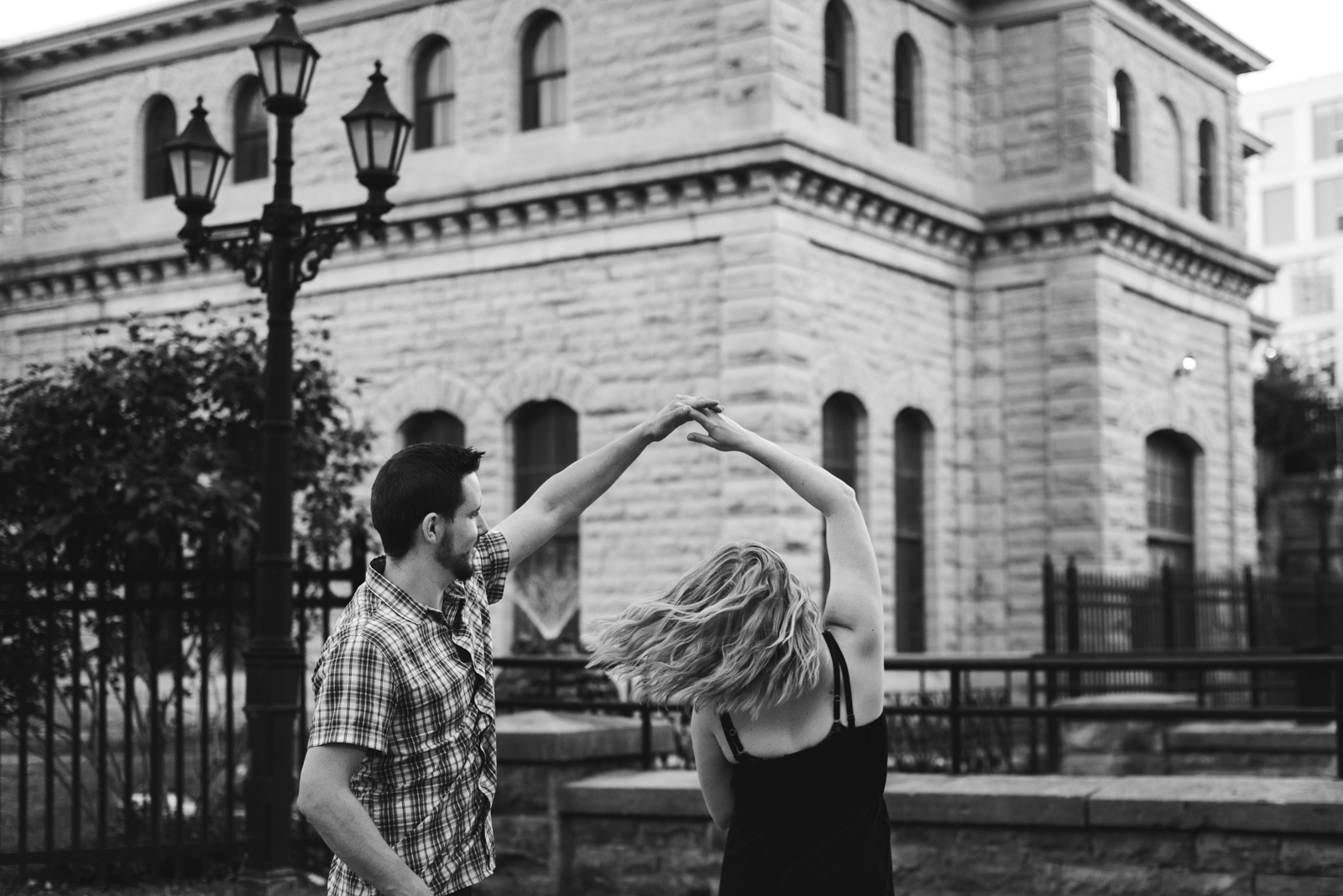 engaged couple dancing in front of the pumphouse in ottawa in black and white