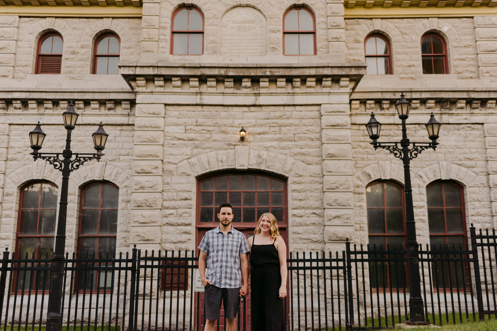 engaged couple holding hands in front of the pumphouse in ottawa