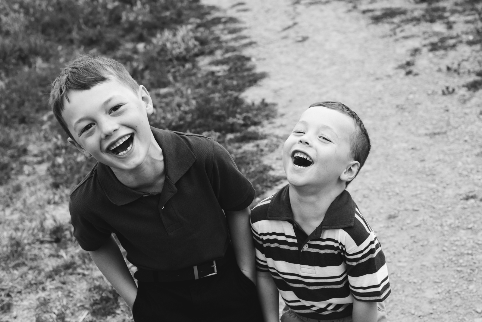 brothers laughing hysterically together looking at the camera