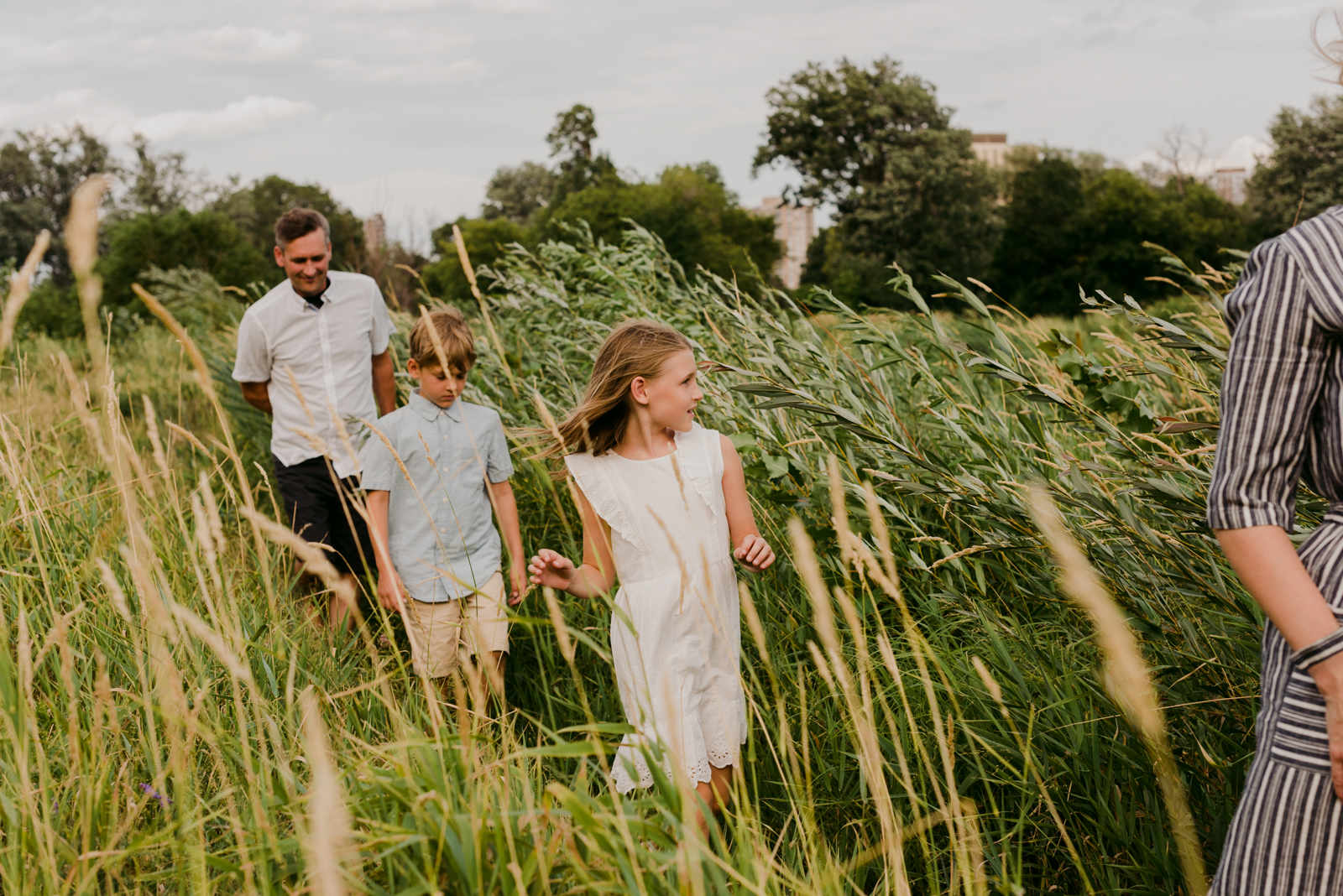 family walking through the tall grass in a park