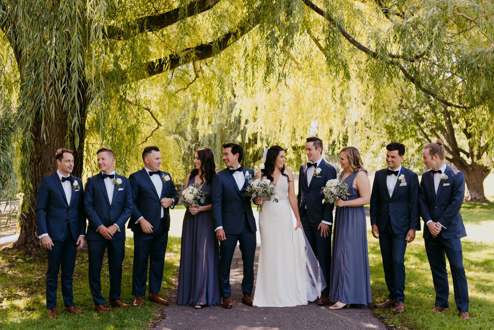 wedding party standing under a willow tree by patterson's creek