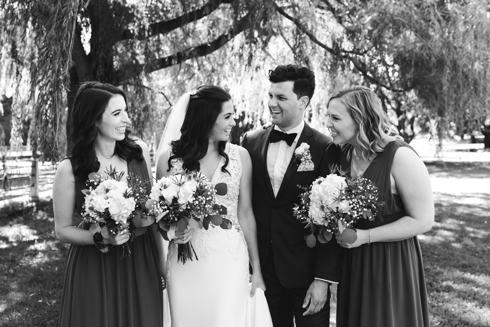 bride and bridal party laughing in black and white by patterson's creek