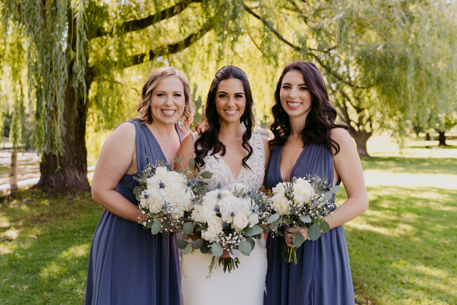 bride and bridesmaids in purple by willow trees by patterson's creek