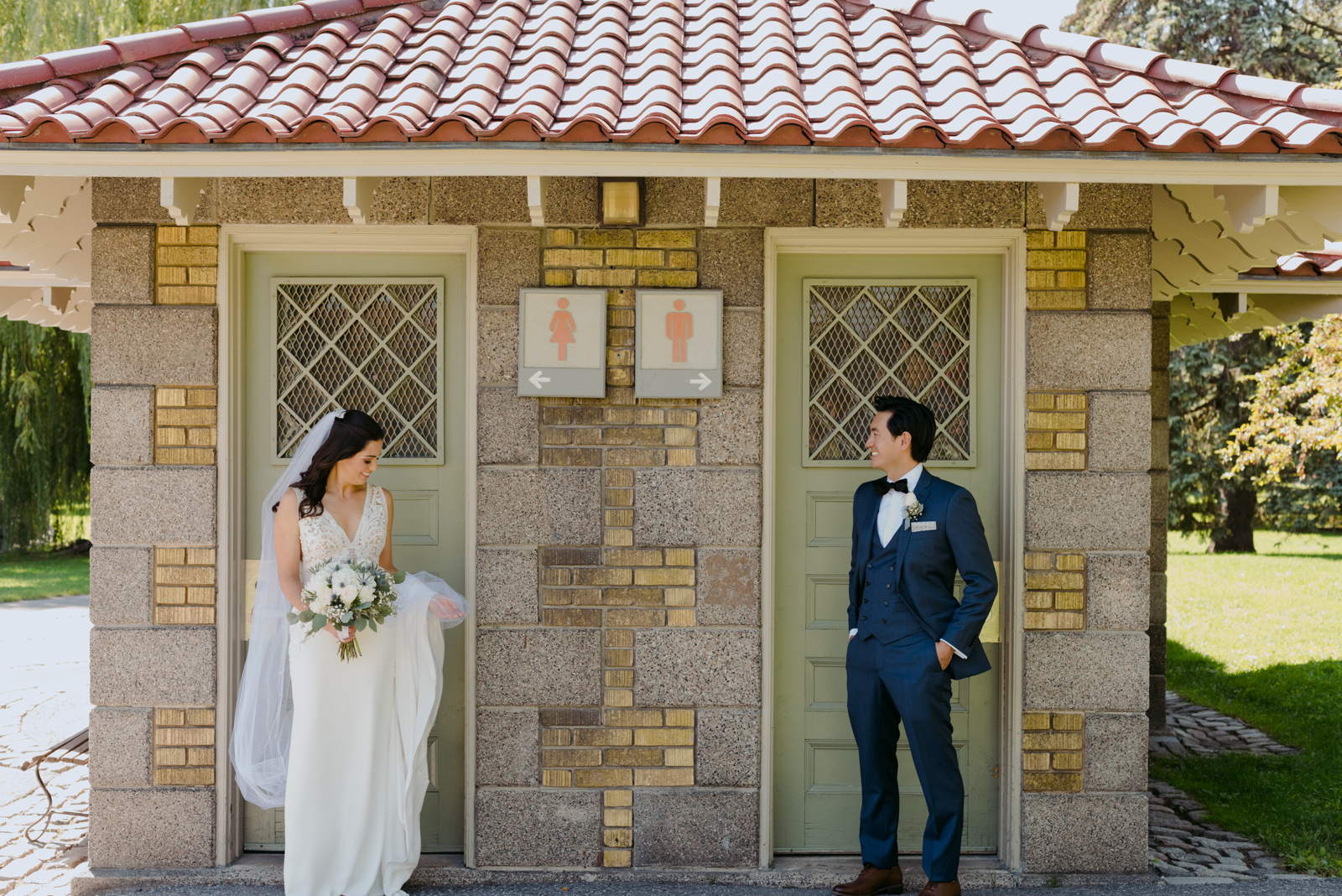 bride and groom outside washroom sign doors by patterson's creek