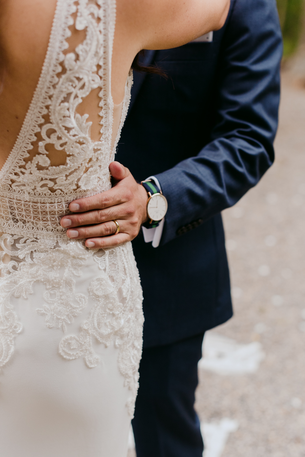 groom's hand with wedding band on bride's hip