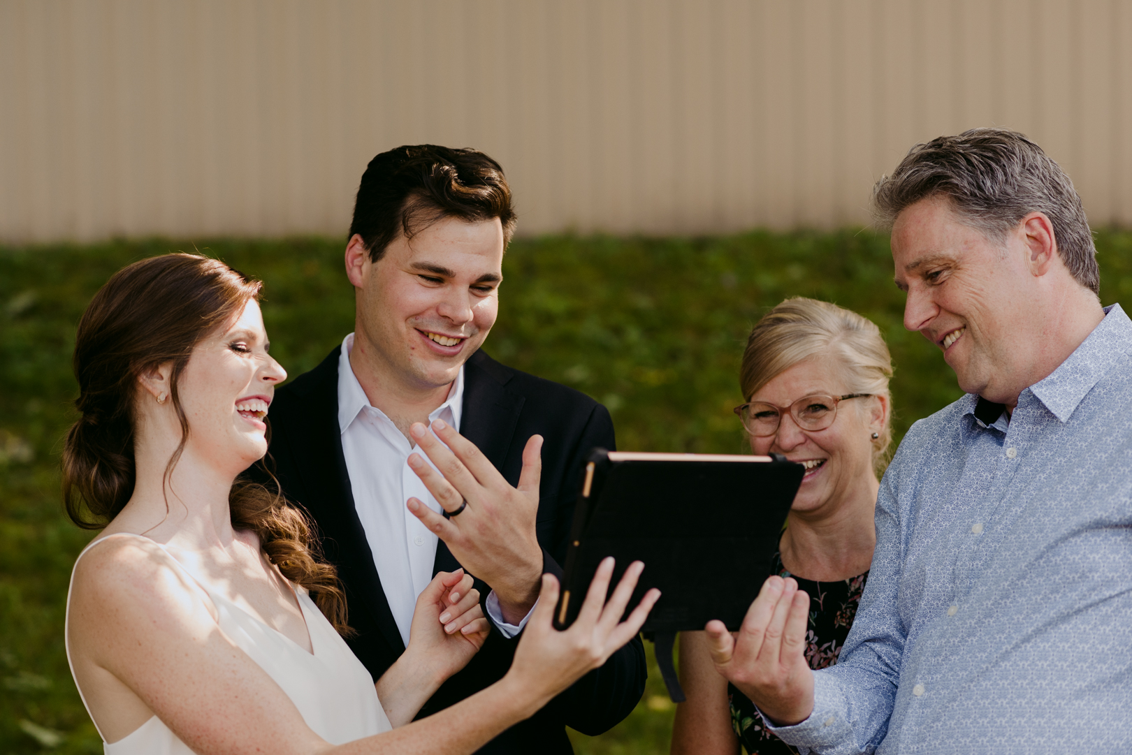 groom showing family his wedding band who are live streaming ceremony