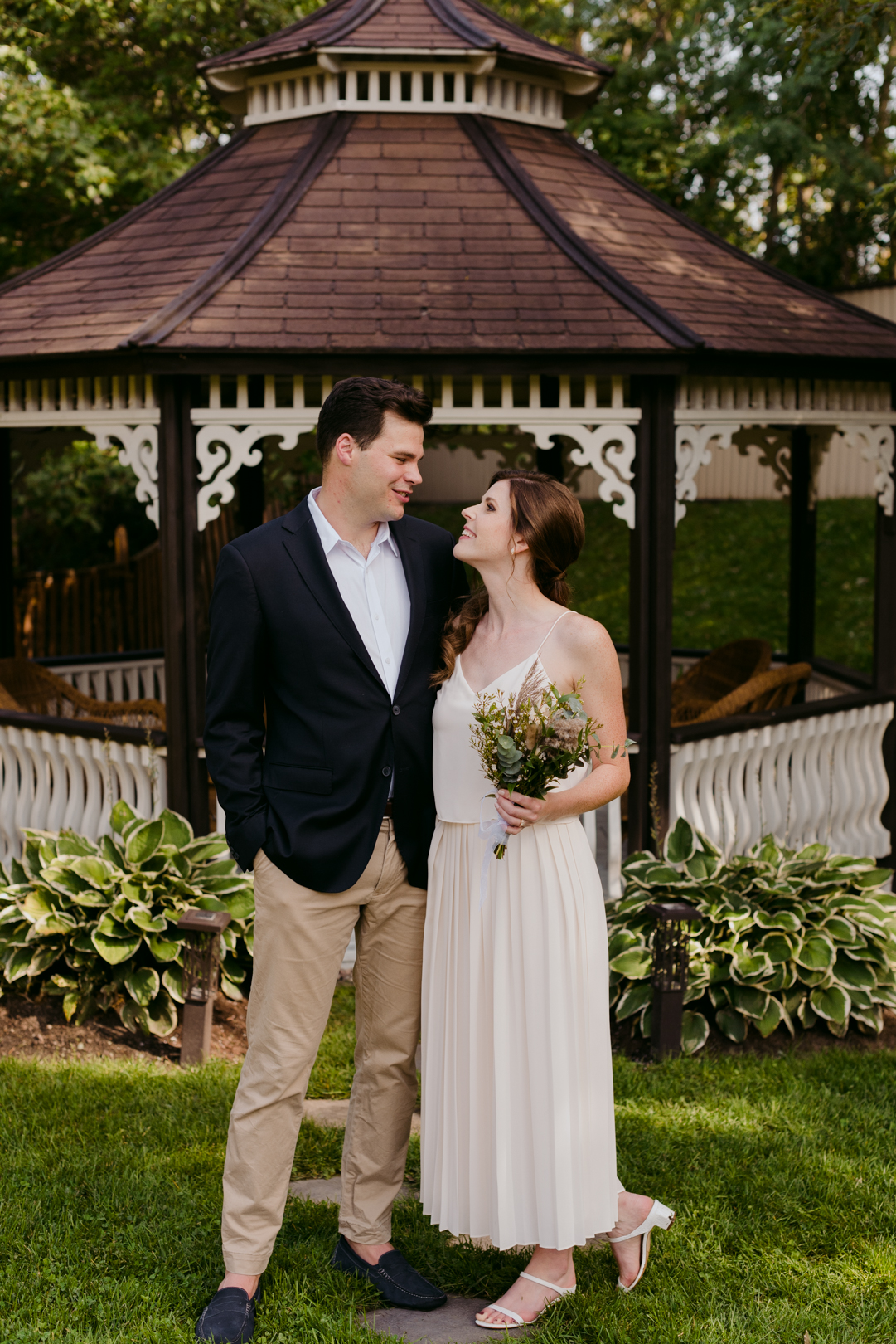 bride and groom in front of pergola at backyard wedding