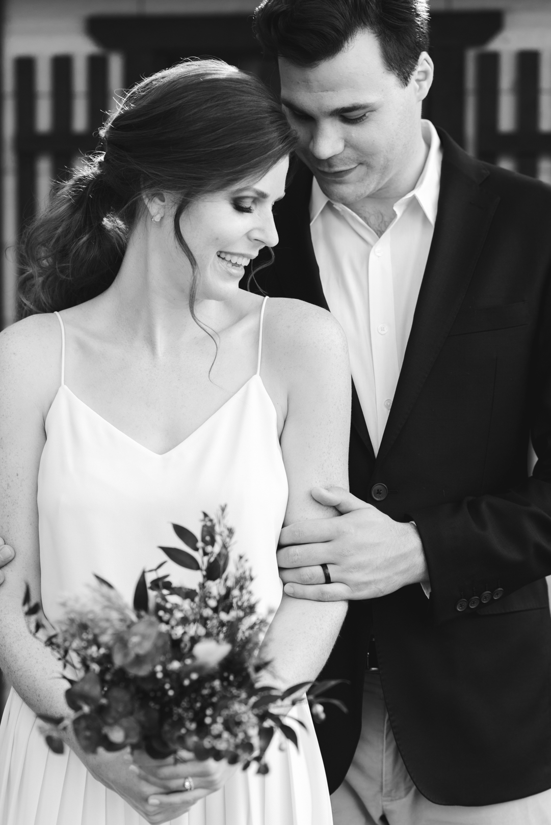 bride and groom cuddling close in black and white