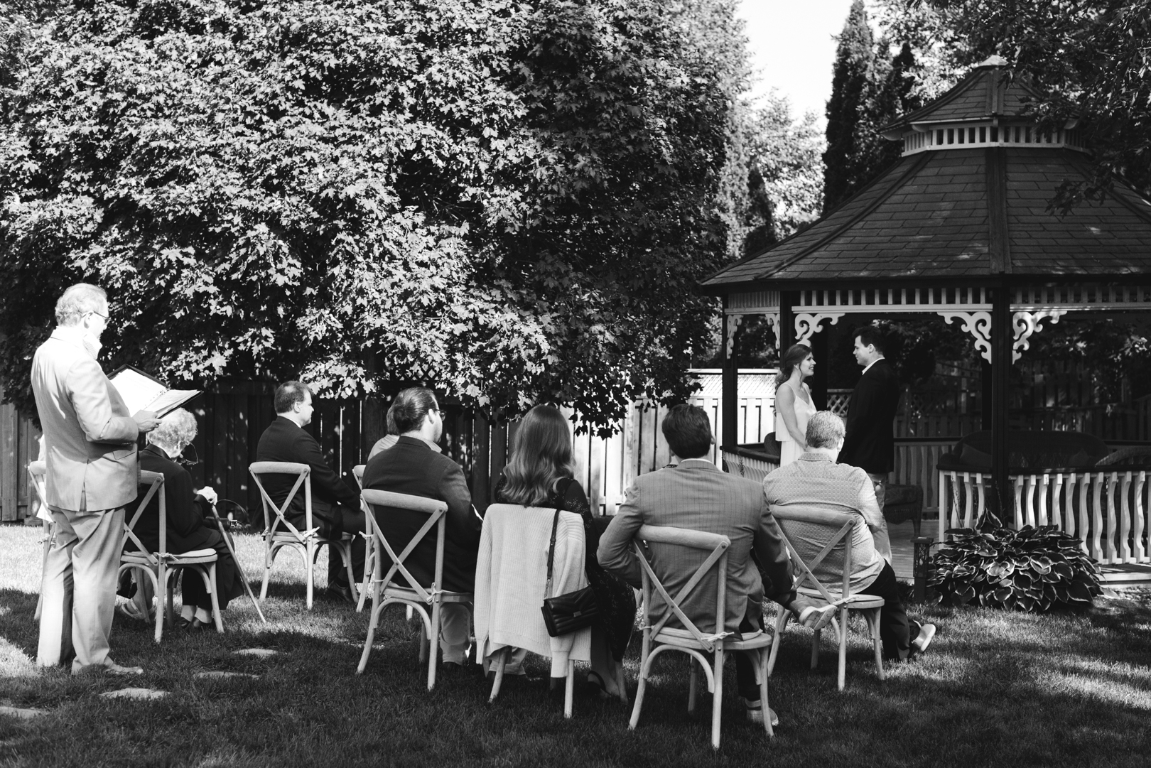 backyard wedding ceremony in front of pergola