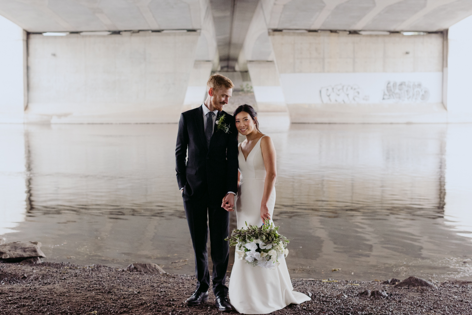 bride and groom underneath a bridge on a rainy wedding day