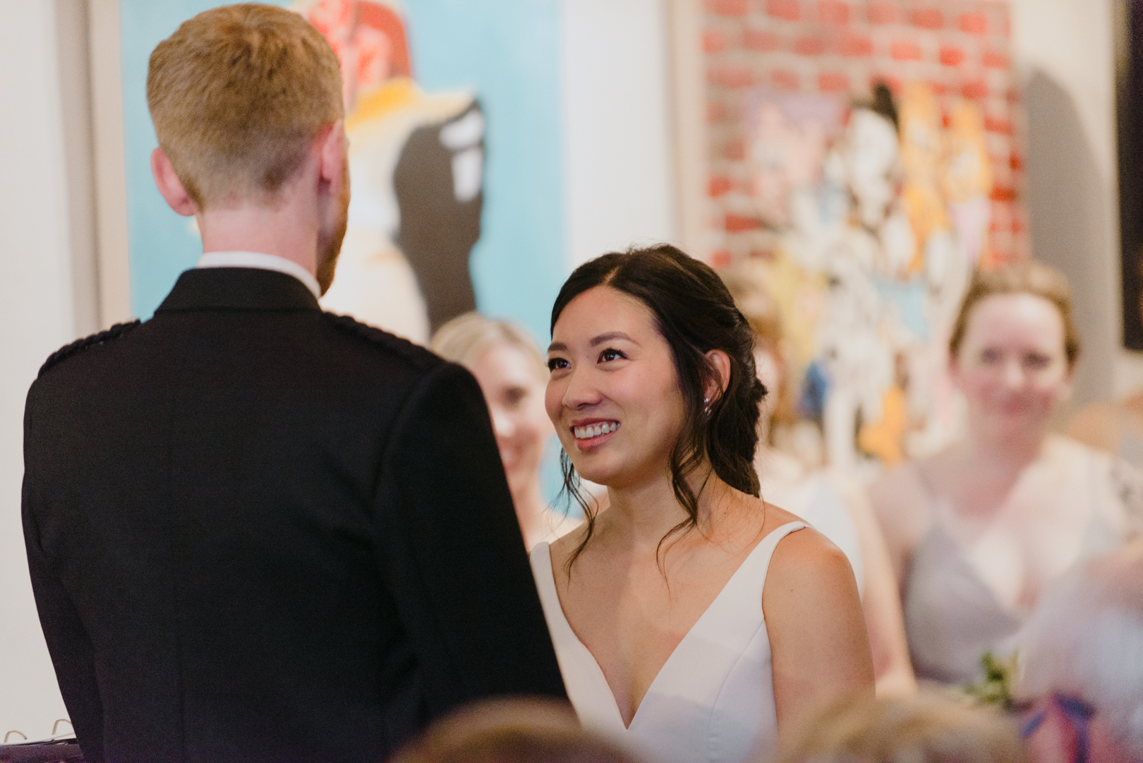 bride smiling at groom during ceremony at Orange Art Gallery wedding