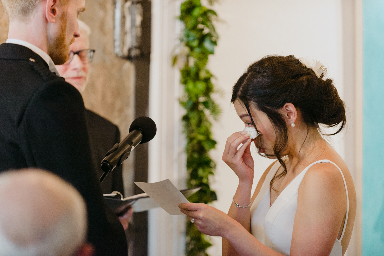 bride wiping away tears during ceremony at Orange Art Gallery wedding