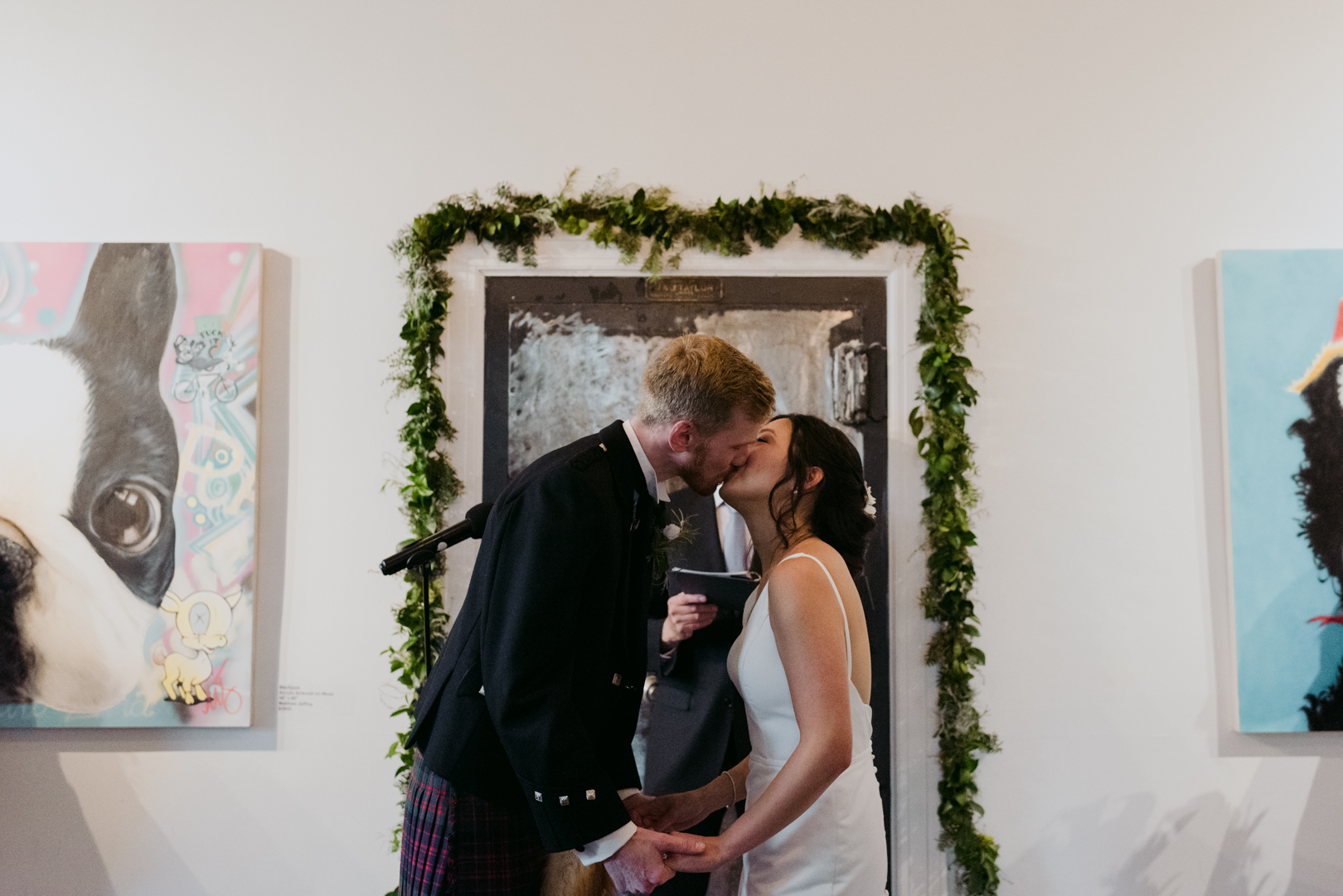 bride and groom first kiss at Orange Art Gallery wedding