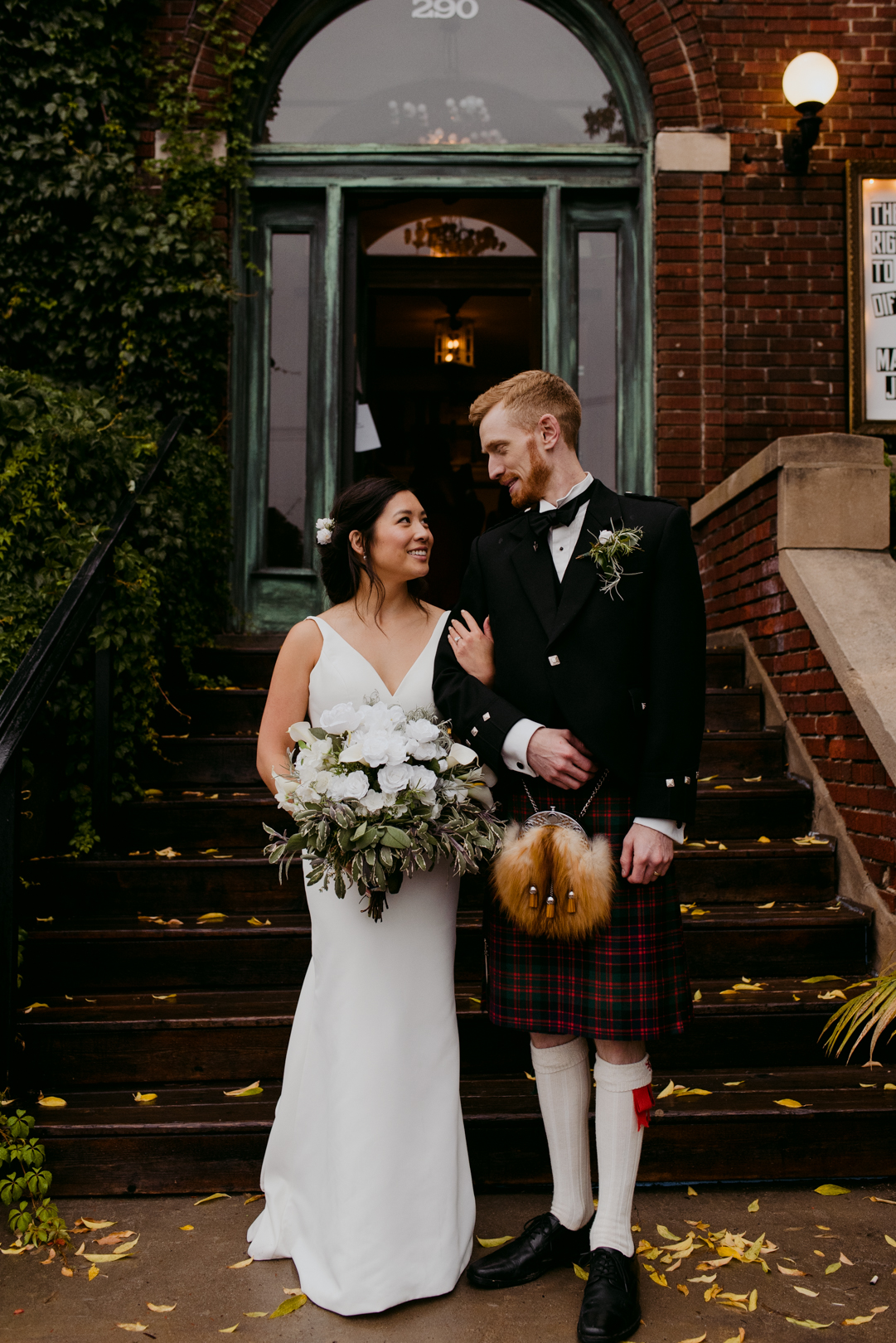 bride and groom wearing kilt standing on steps of the Orange Art Gallery