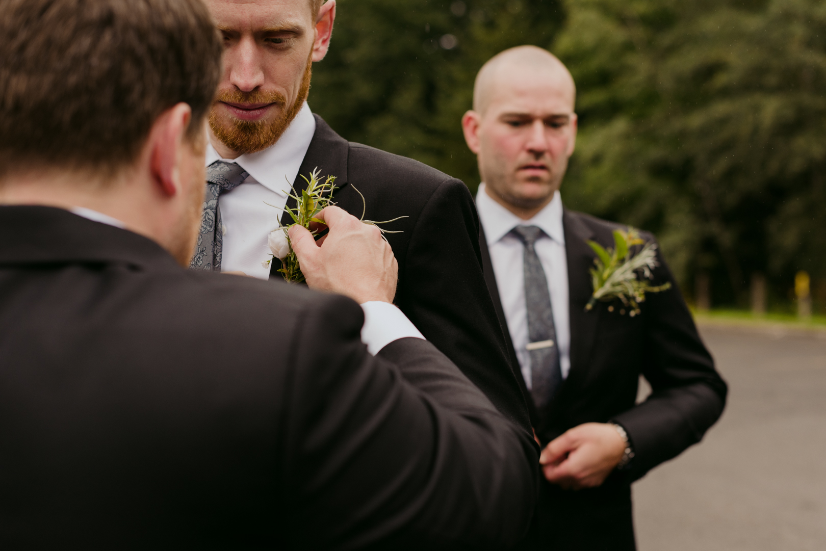 best man putting on groom's boutonniere